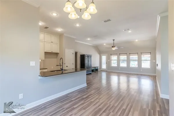 a view of a kitchen with wooden floor and window