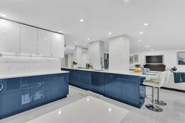 a kitchen with stainless steel appliances kitchen island granite countertop a refrigerator and cabinets