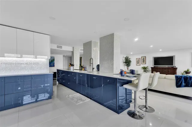 a living room with furniture a flat screen tv and kitchen view