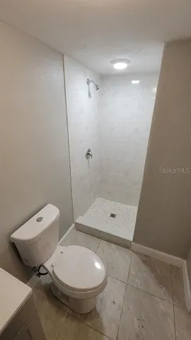 a bathroom with a toilet a sink and shower