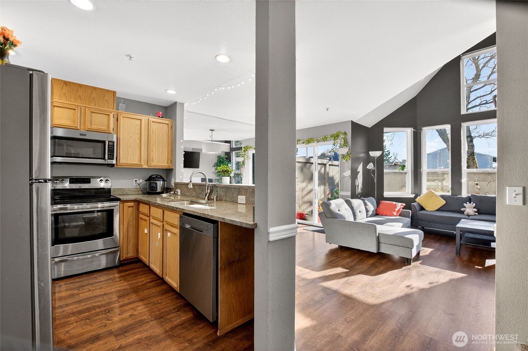 6615 South 239th Place, Unit R109 Kent, WA 98032 - Photo 13 of 40 a kitchen with stainless steel appliances granite countertop a stove top oven a refrigerator a sink and dishwasher with wooden floor