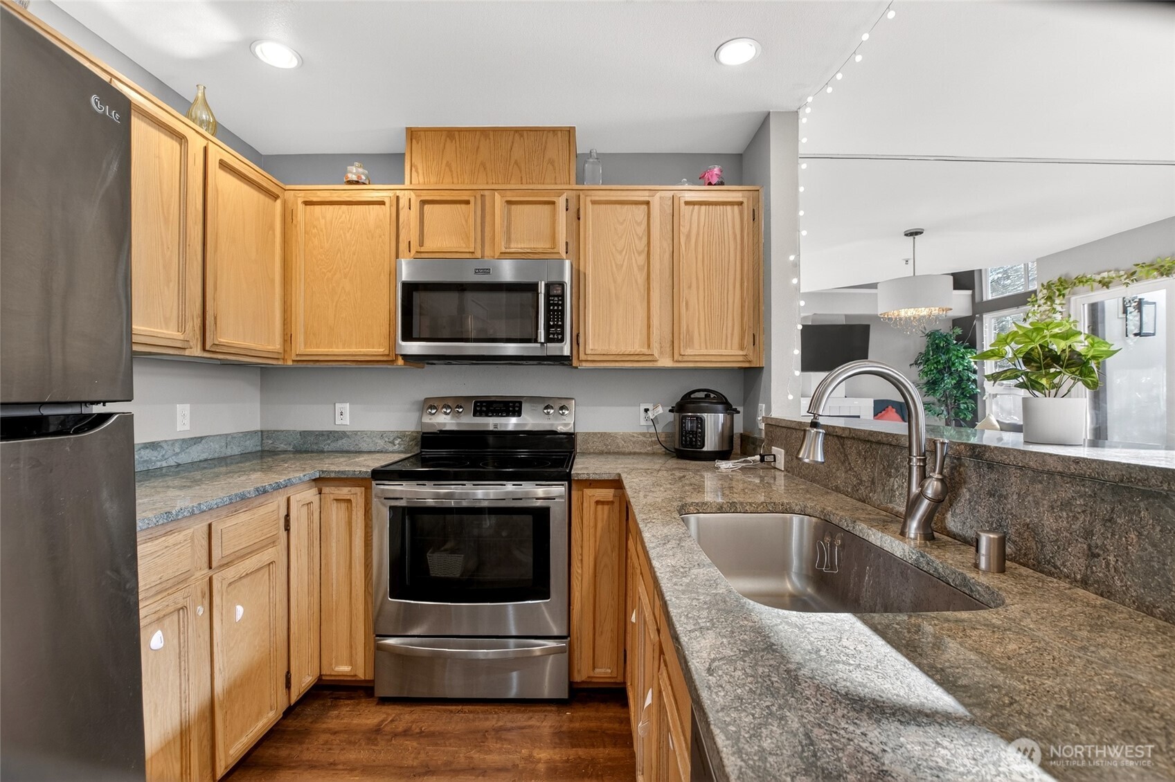 6615 South 239th Place, Unit R109 Kent, WA 98032 - Photo 15 of 40 a kitchen with stainless steel appliances granite countertop a sink a stove top oven a counter space and cabinets