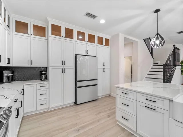 a dining room with wooden floor a chandelier a wooden table and chairs