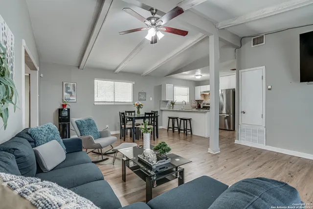 a living room with furniture and kitchen view