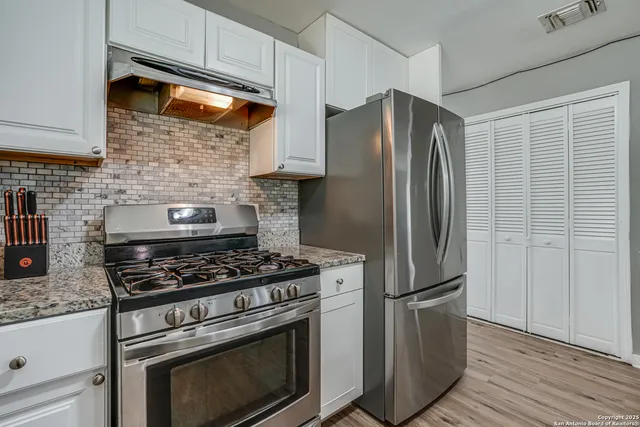 a kitchen with stainless steel appliances granite countertop a stove and a refrigerator