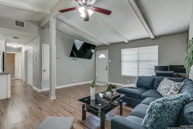 a living room with furniture and a wooden floor