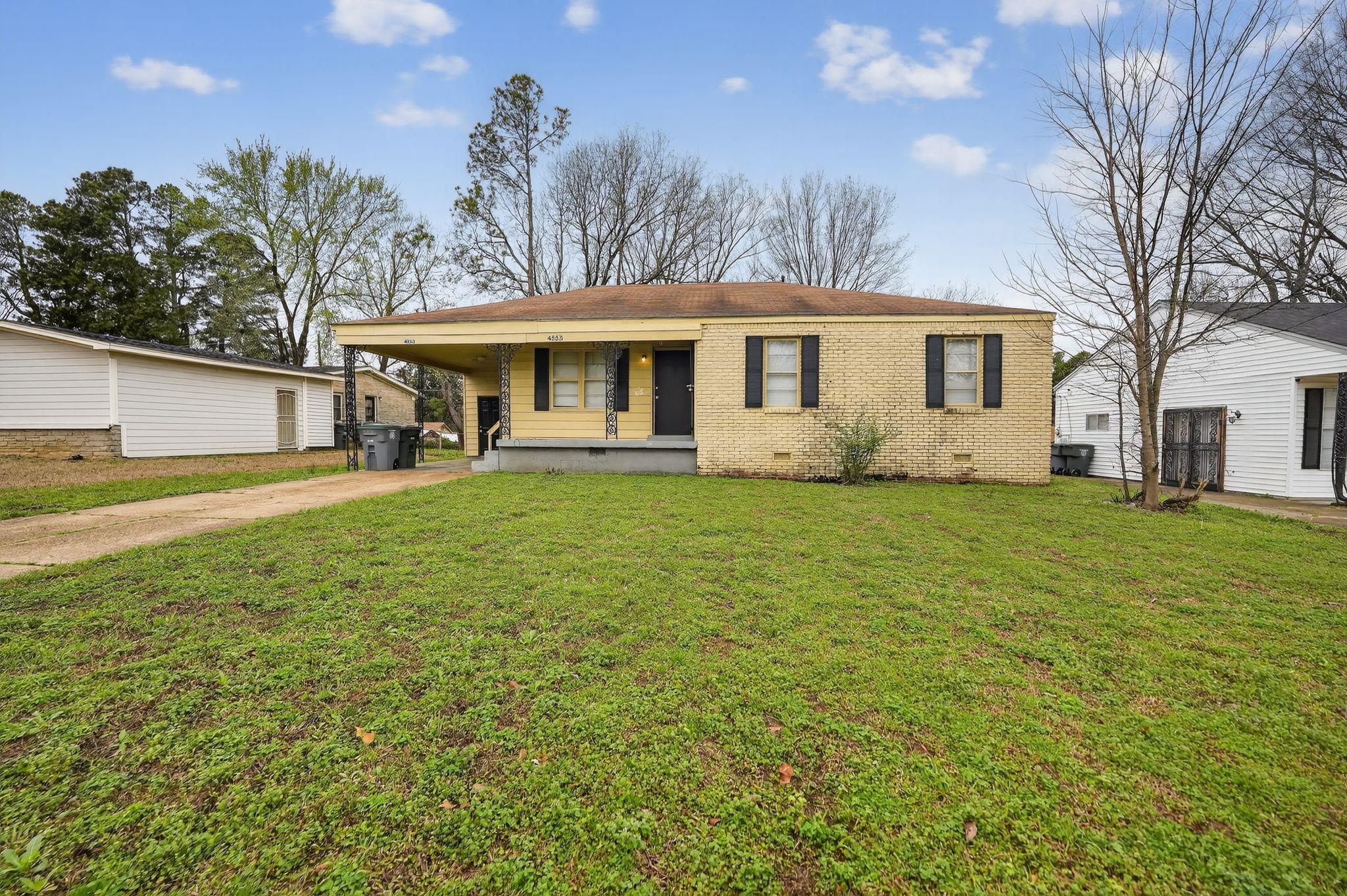 a front view of a house with a yard and trees