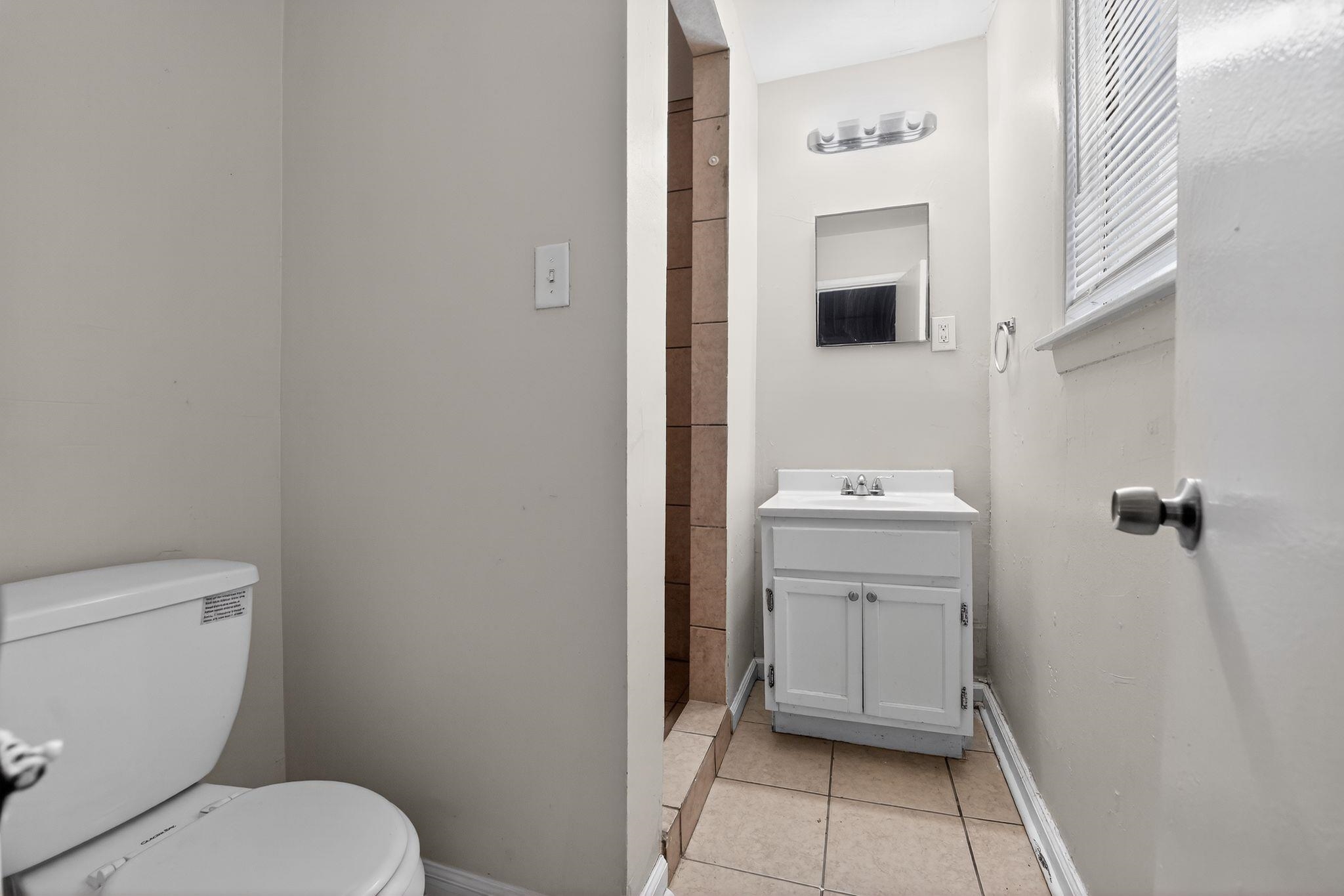 4553 Neely Road Memphis, TN 38109 - Photo 14 of 33 a bathroom with a toilet a sink and mirror