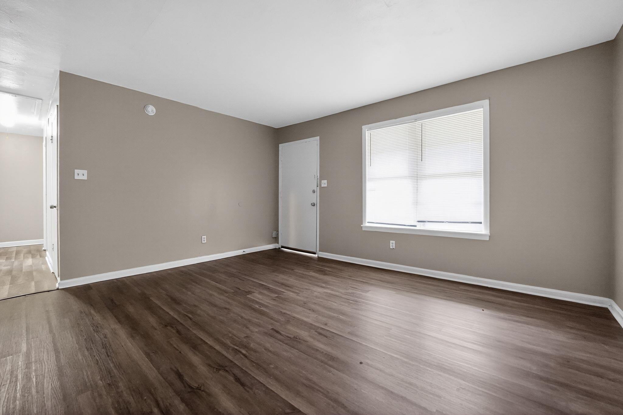 4553 Neely Road Memphis, TN 38109 - Photo 2 of 33 a view of an empty room with wooden floor and a window