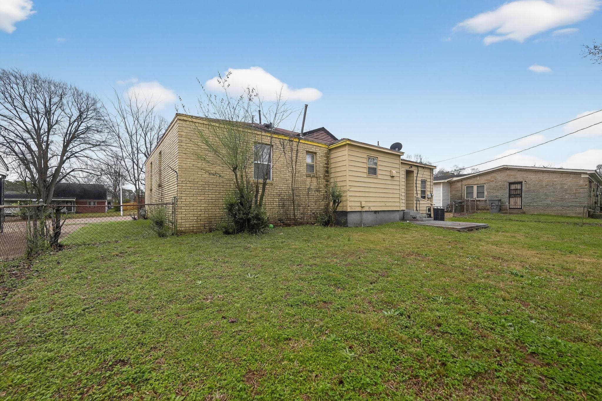 4553 Neely Road Memphis, TN 38109 - Photo 22 of 33 a view of a house with backyard and a tree