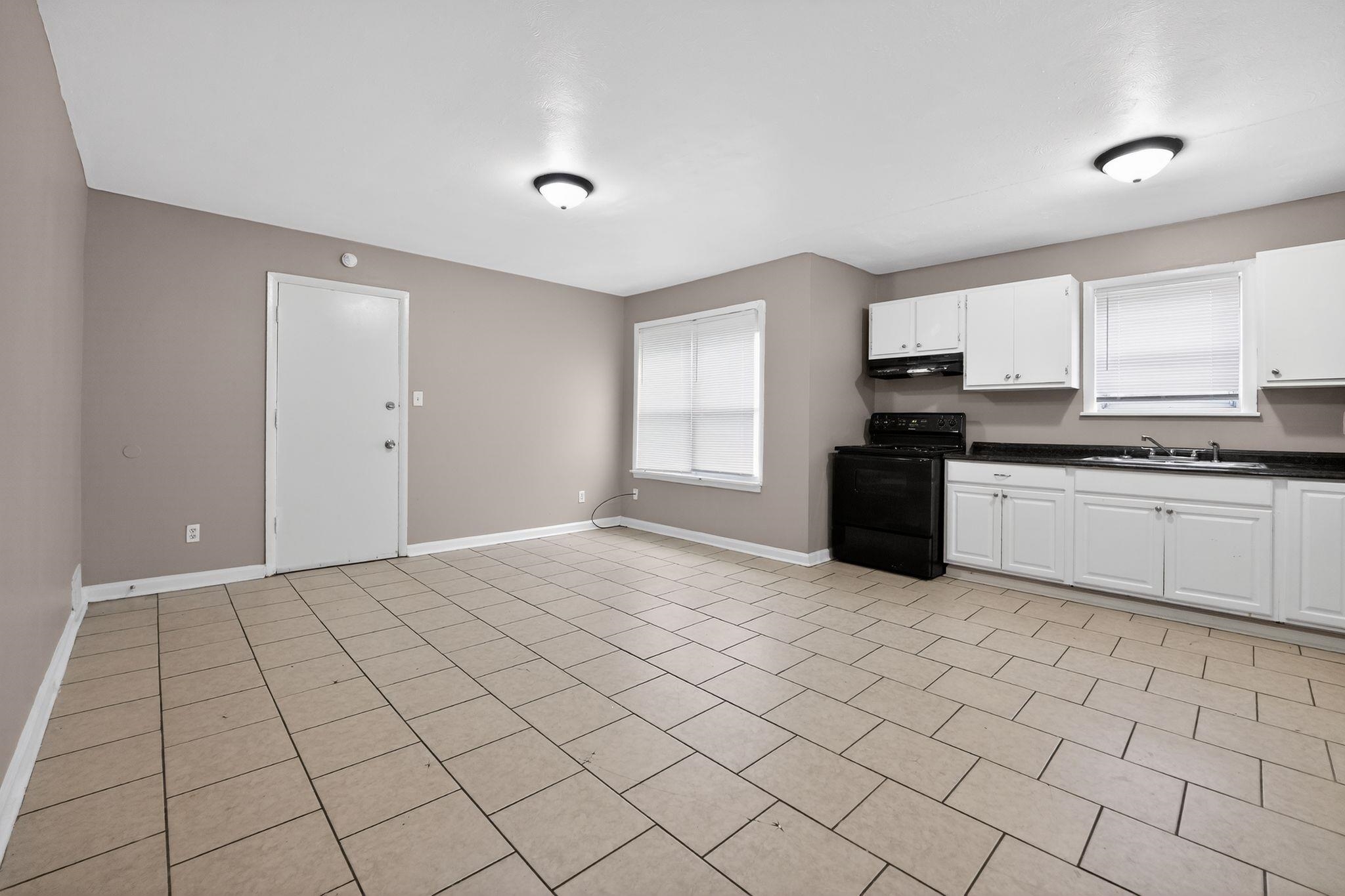 4553 Neely Road Memphis, TN 38109 - Photo 4 of 33 a kitchen with stainless steel appliances a sink a stove a microwave a counter top space cabinets and a window