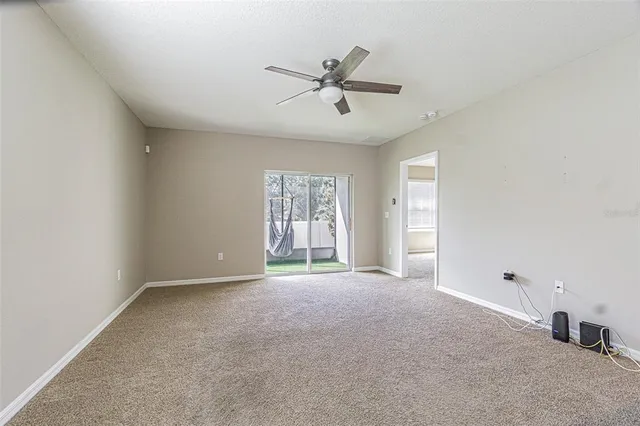 a view of a livingroom with a ceiling fan and window