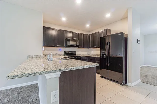 a kitchen with stainless steel appliances granite countertop a refrigerator and a sink