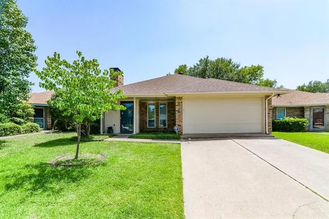 a front view of a house with a yard and trees