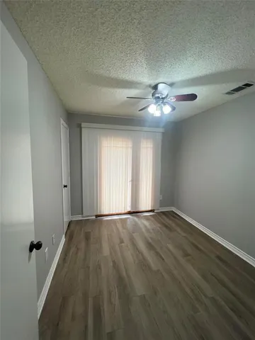 a view of an empty room and chandelier fan
