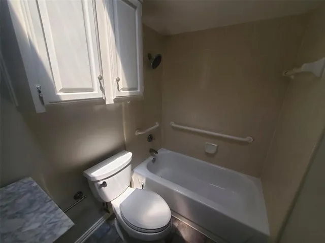 a white toilet sitting next to a bathtub