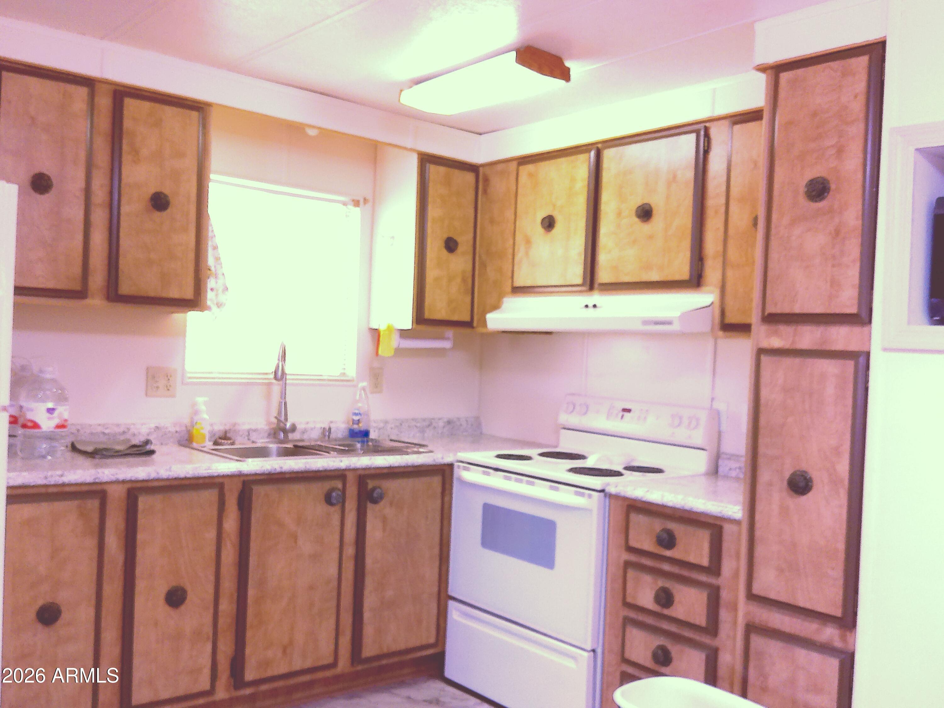 800 West Apache Trail, Unit 142 Apache Junction, AZ 85120 - Photo 13 of 33 a kitchen with a sink a stove and cabinets