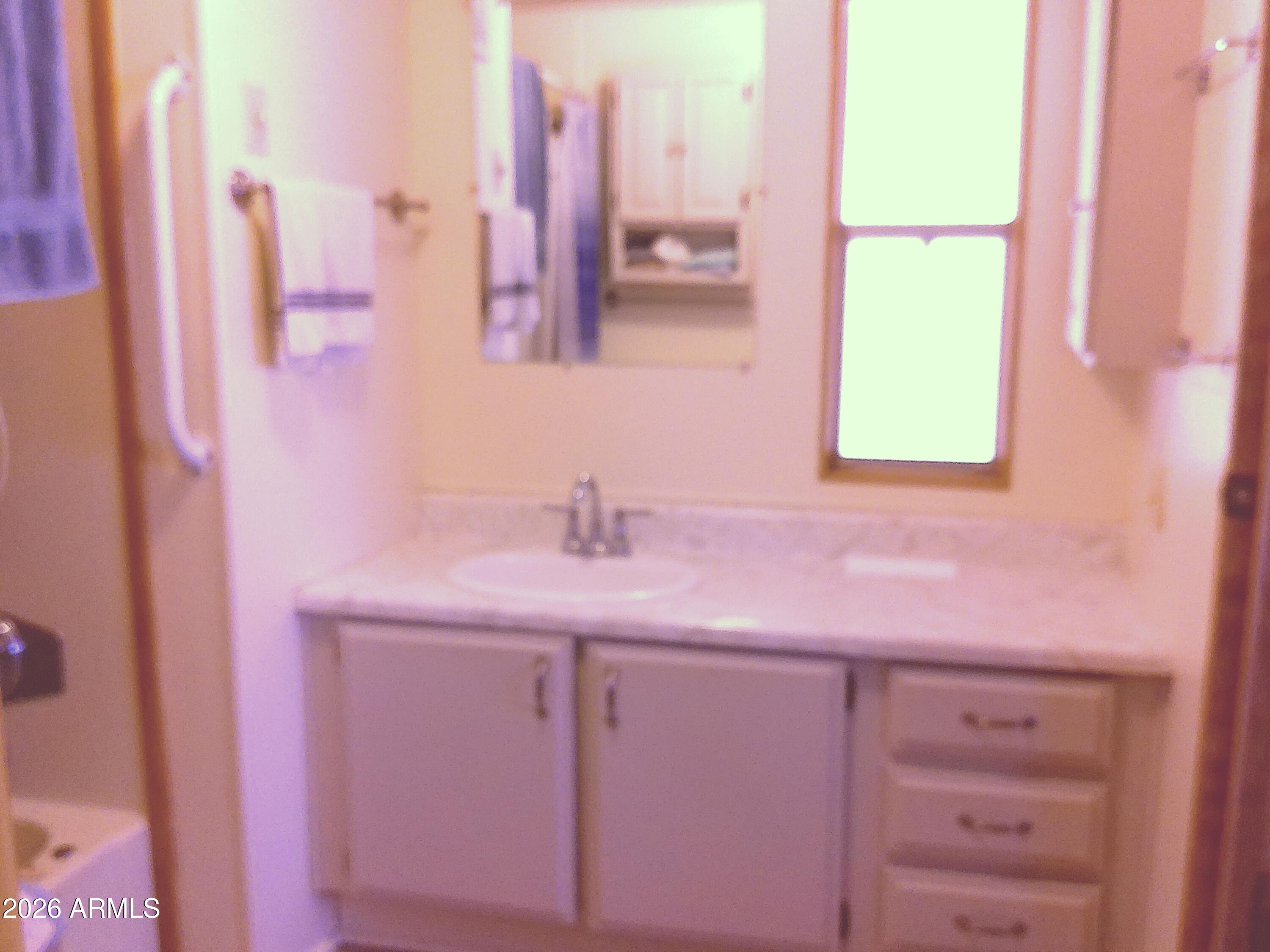 800 West Apache Trail, Unit 142 Apache Junction, AZ 85120 - Photo 16 of 33 a bathroom with a sink a mirror and a window
