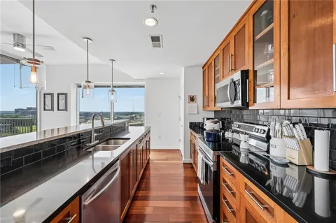 a kitchen with stainless steel appliances a stove a sink and a wooden floors
