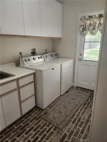 a utility room with cabinets washer and dryer