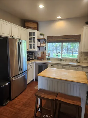 a kitchen with kitchen island a counter top space cabinets and stainless steel appliances
