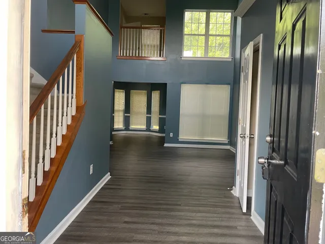a view of a hallway with wooden floor and staircase