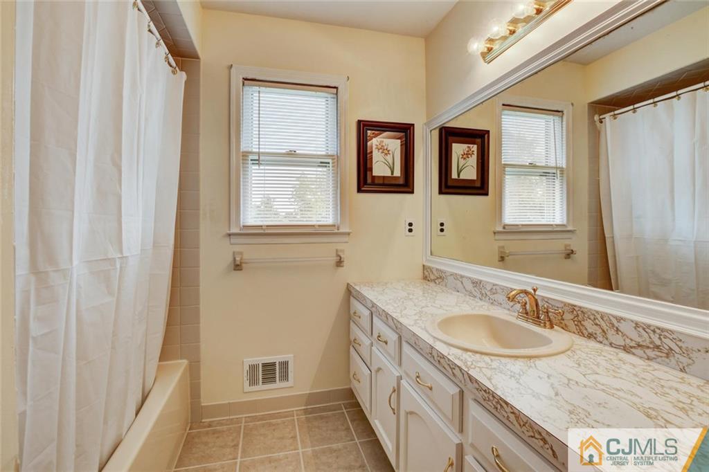 8 Vince Road Somerset, NJ 08873 - Photo 10 of 24 a bathroom with a granite countertop sink and a mirror