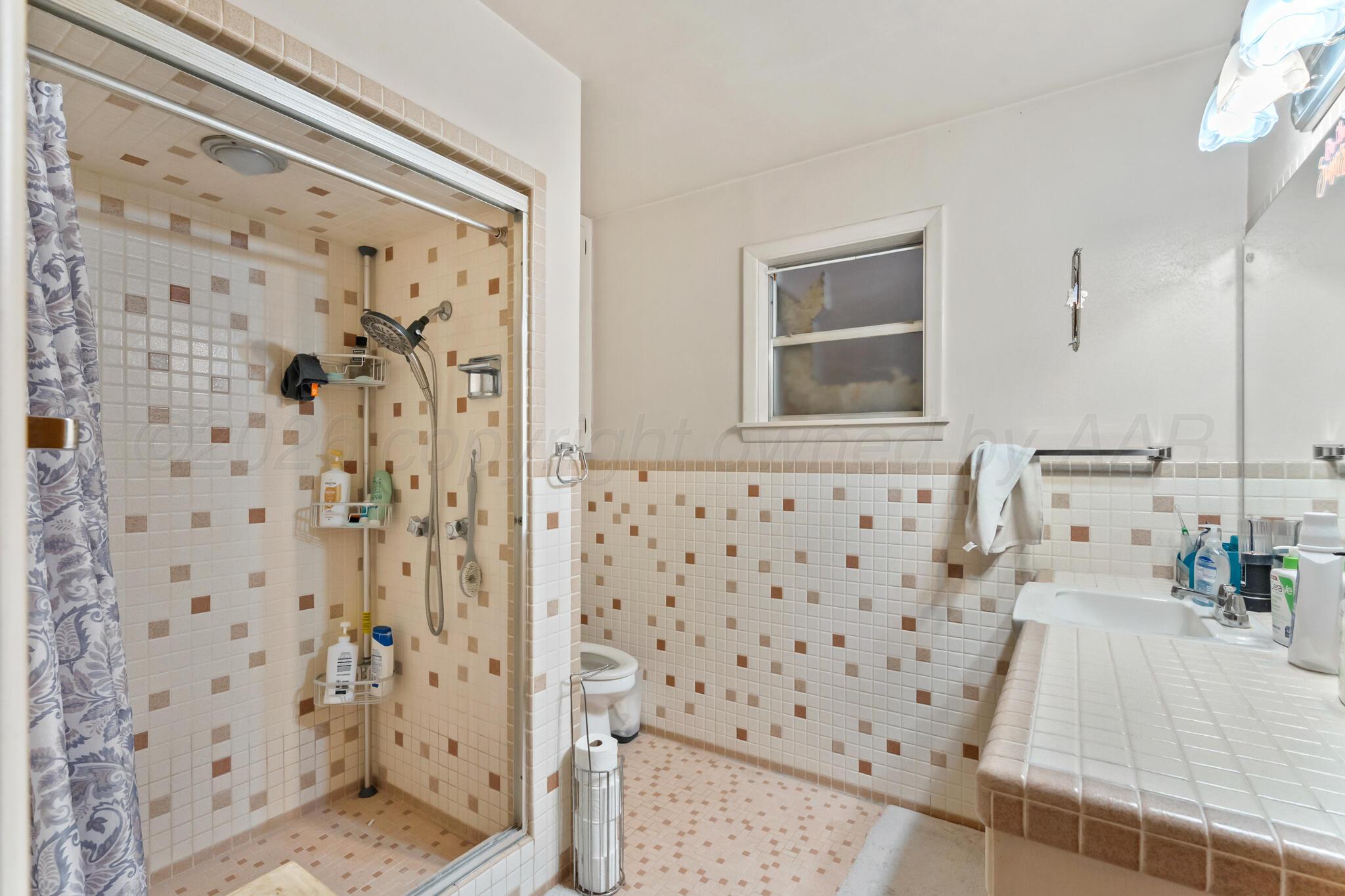 2217 Peach Tree Street Amarillo, TX 79109 - Photo 19 of 26 a bathroom with a shower curtain