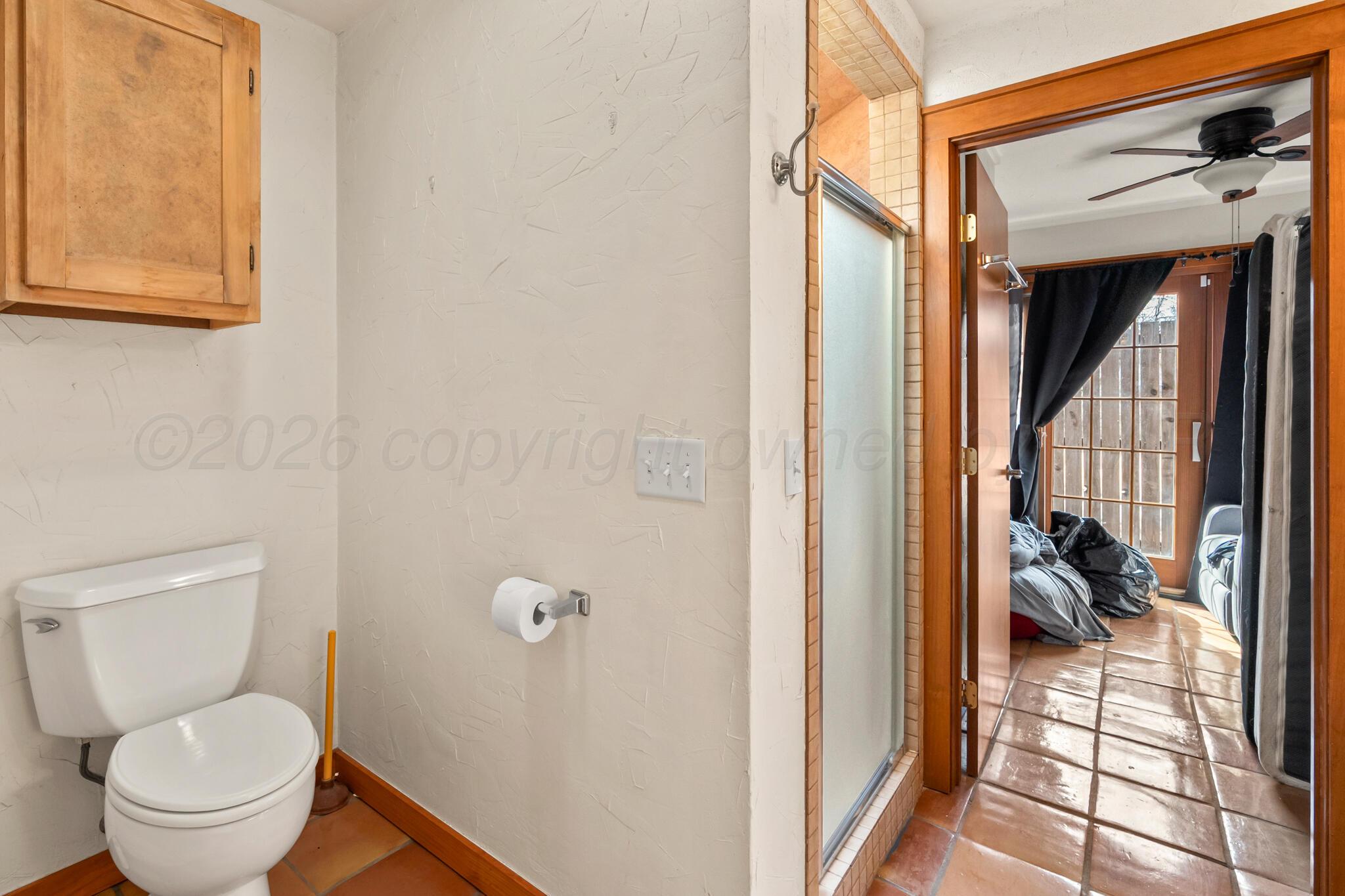 2217 Peach Tree Street Amarillo, TX 79109 - Photo 23 of 26 a bathroom with a toilet and a shower curtain