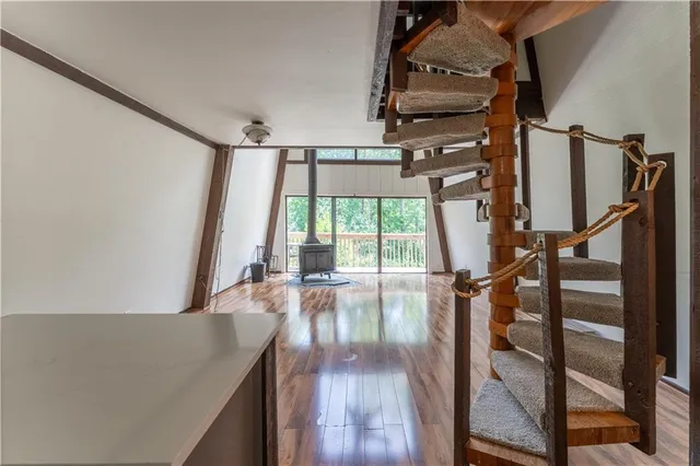 a view of a livingroom with wooden floor and a floor to ceiling window