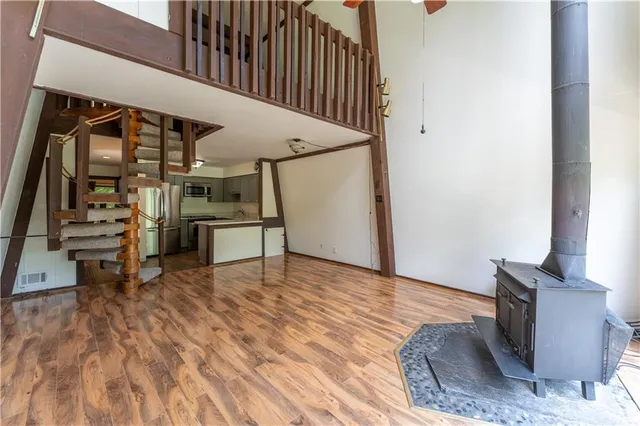 a kitchen with stainless steel appliances a refrigerator a sink a stove a table and chairs