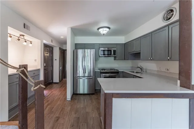 a kitchen with a refrigerator sink and cabinets