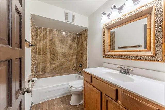 a view of a livingroom with wooden floor and a ceiling fan