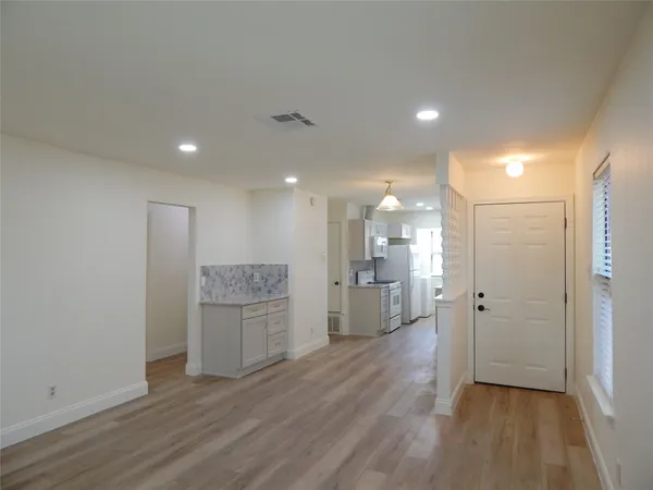 a open kitchen with a refrigerator and a stove top oven