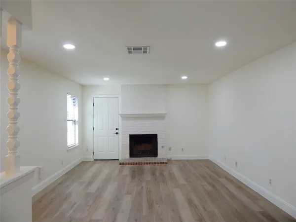 an empty room with a fireplace and window