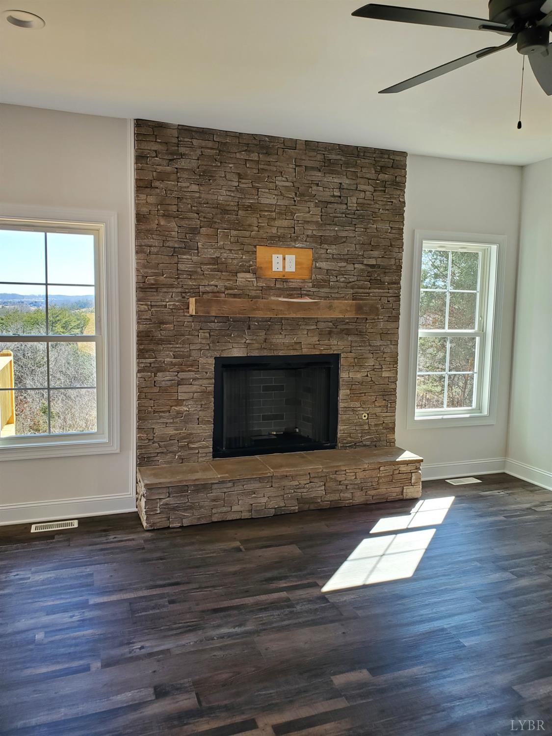 3059 Bells Mill Road Goode, VA 24556 - Photo 2 of 4 a view of an empty room with wooden floor and a fireplace