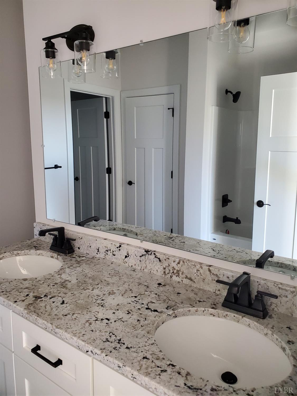 3059 Bells Mill Road Goode, VA 24556 - Photo 4 of 4 a bathroom with a granite countertop sink and a mirror