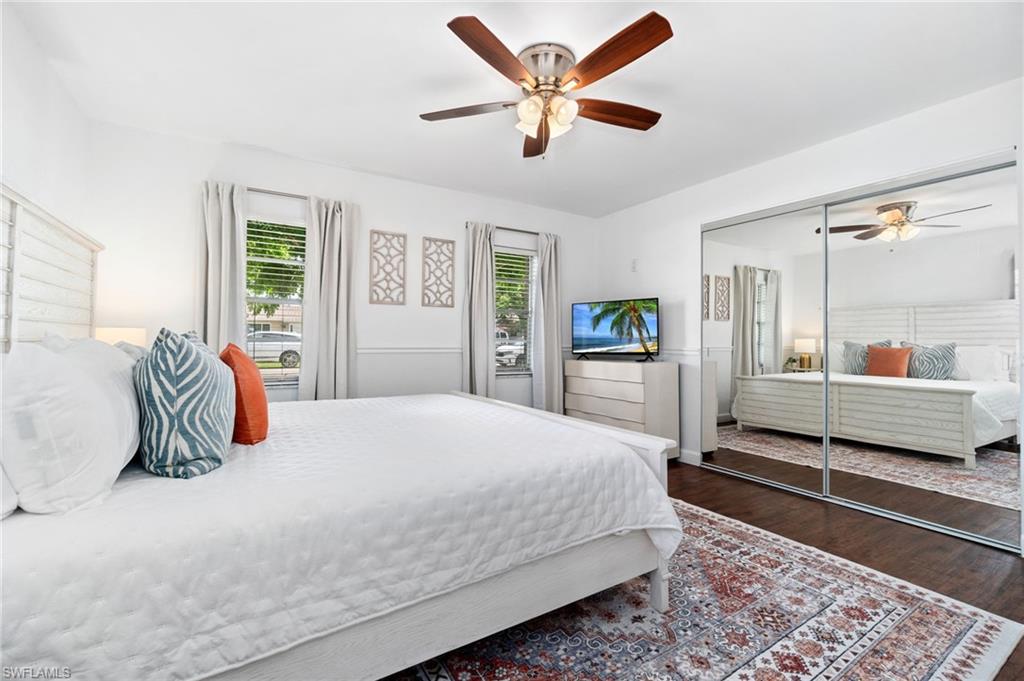 3543 Corana Way Naples, FL 34105 - Photo 15 of 26 a bedroom with a large bed and a chandelier