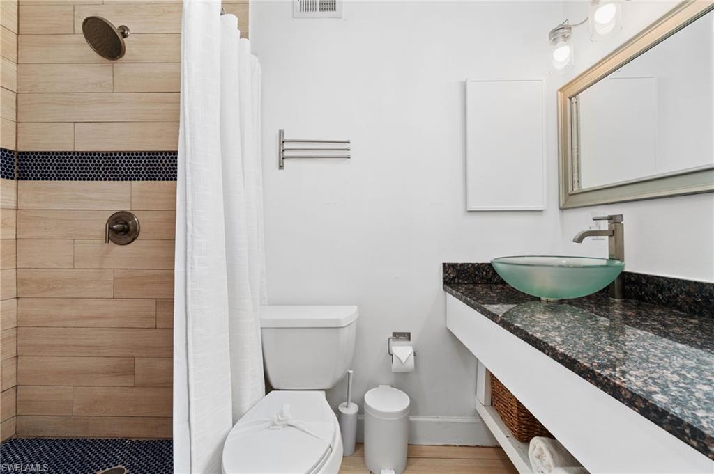 3543 Corana Way Naples, FL 34105 - Photo 16 of 26 a bathroom with a granite countertop toilet and a sink