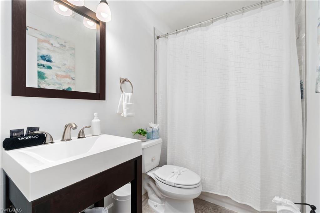 3543 Corana Way Naples, FL 34105 - Photo 20 of 26 a bathroom with a sink a toilet and a mirror