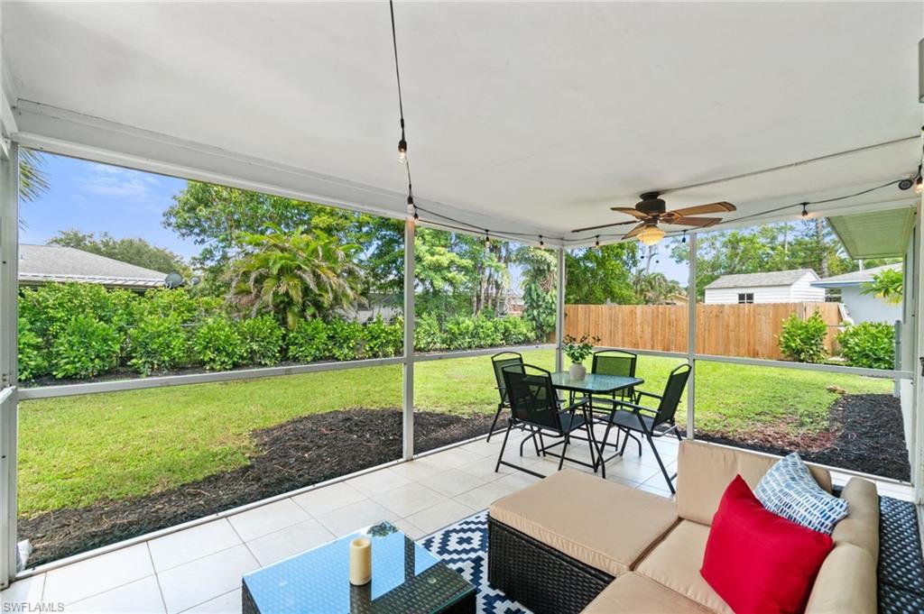 3543 Corana Way Naples, FL 34105 - Photo 23 of 26 a view of a patio with dining table chairs and a yard