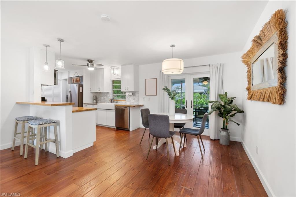 3543 Corana Way Naples, FL 34105 - Photo 4 of 26 a open dining room with kitchen island wooden floor and stainless steel appliances