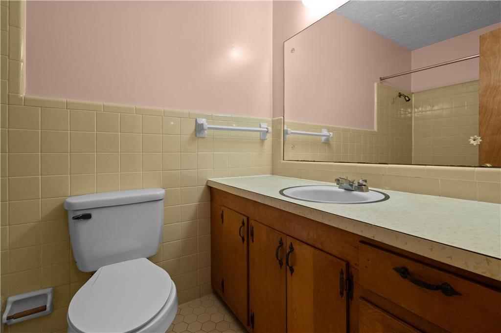 768 Burwell Road Carrollton, GA 30117 - Photo 14 of 42 a bathroom with a granite countertop toilet sink and mirror