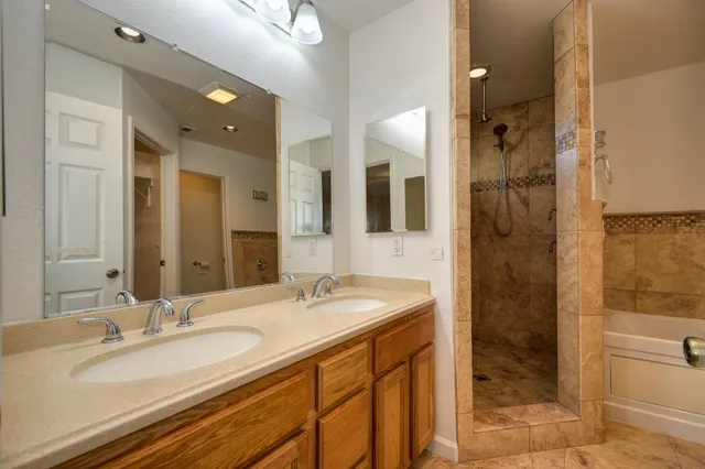 a bathroom with a granite countertop sink mirror and shower