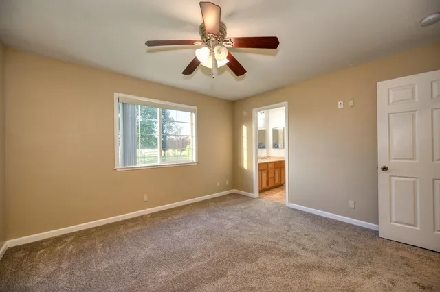 an empty room with closet and a chandelier fan