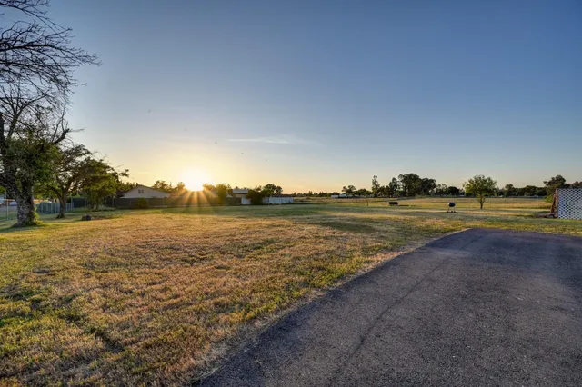 a view of a field with a view of building in background