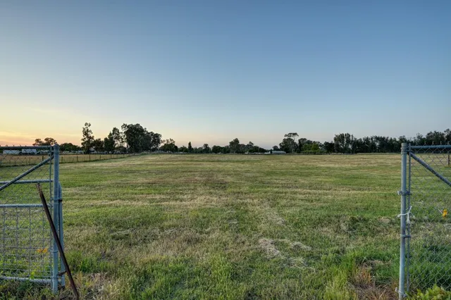 an aerial view of a residential houses with outdoor space and lake view