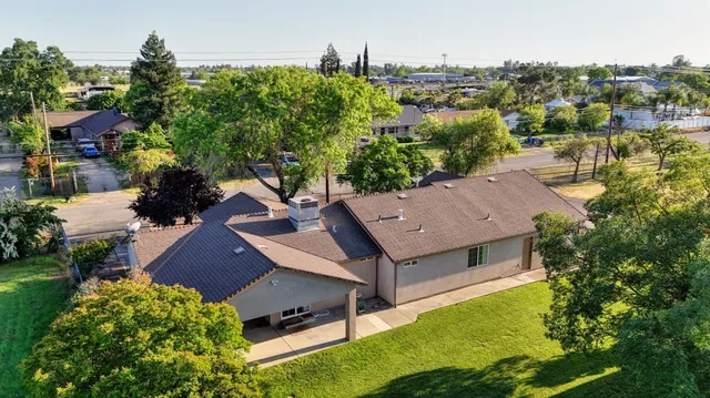an aerial view of residential houses with outdoor space and trees