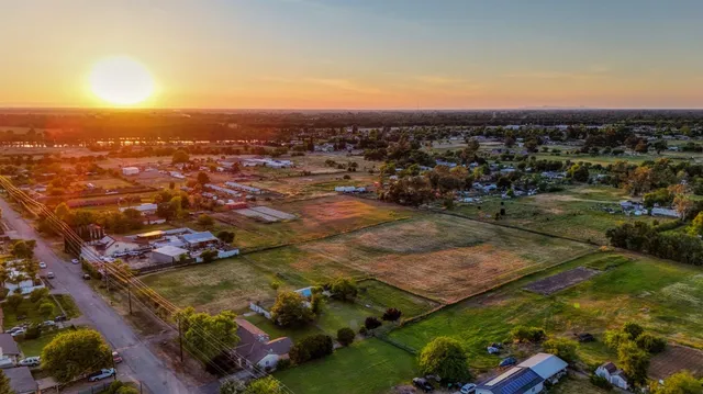an aerial view of residential houses with outdoor space and trees