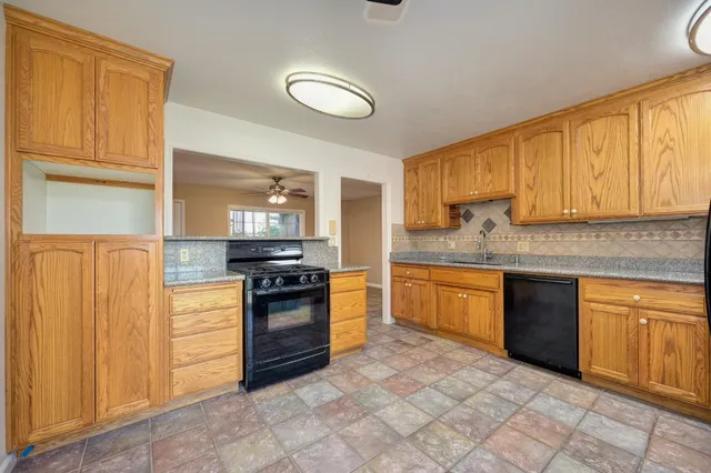 a kitchen with stainless steel appliances granite countertop a stove top oven a sink and dishwasher